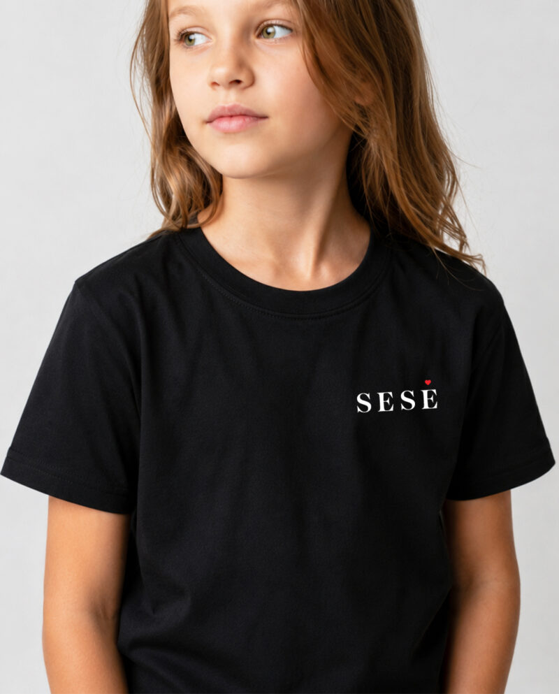 Vaikiški marškinėliai su užrašu „Sesė“ ir maža širdele priekyje.